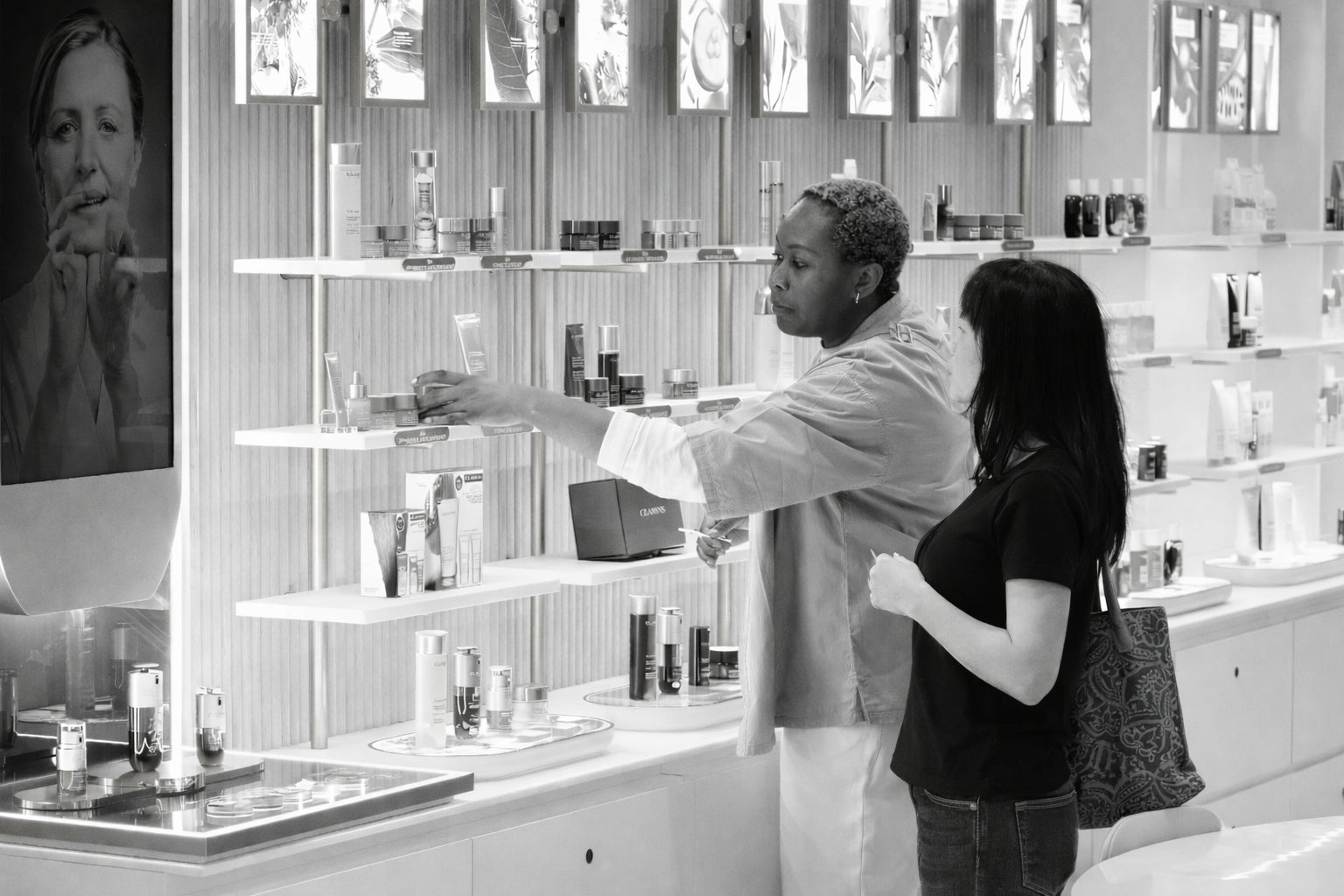 Two women in a store with shelves stocked with products