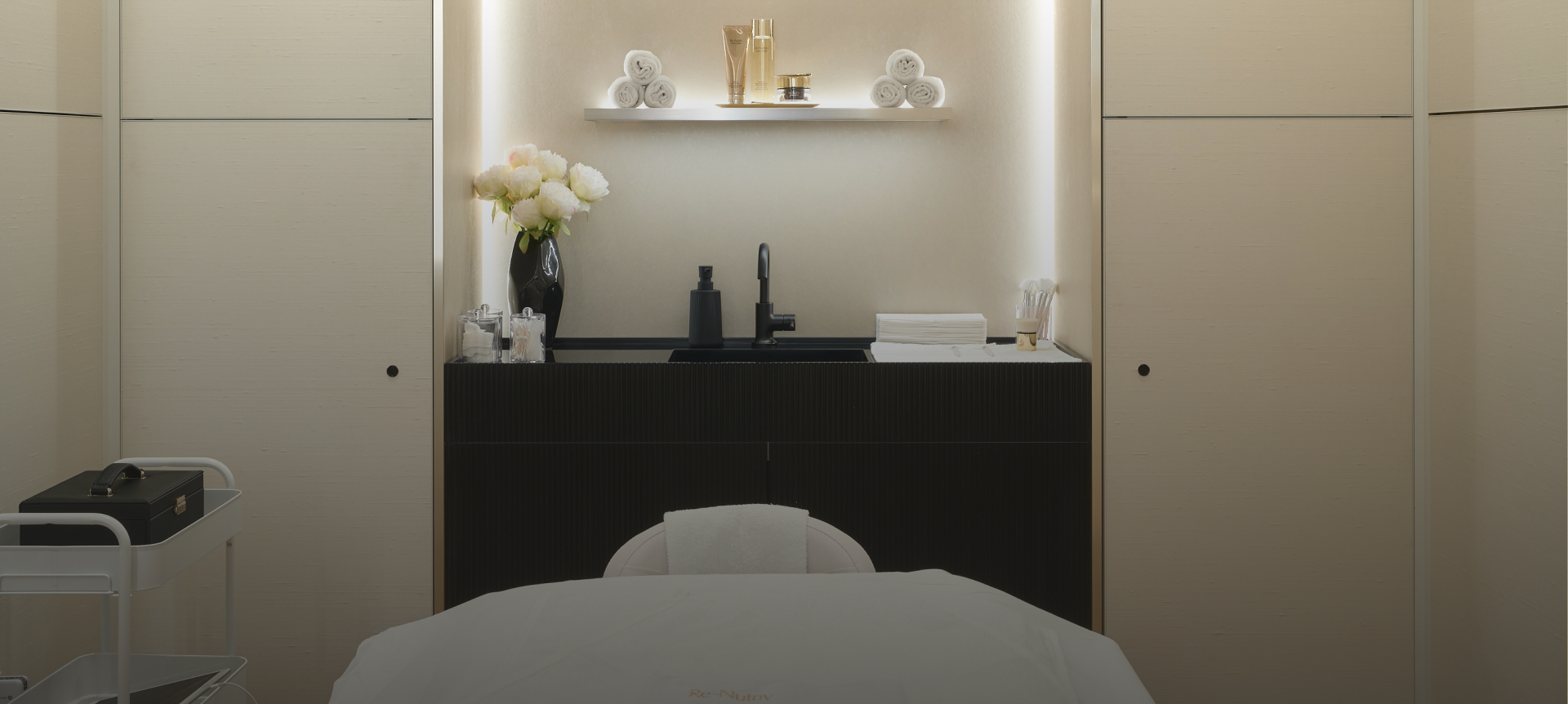 Modern interior of a spa or clinic with a treatment table and decorative elements.